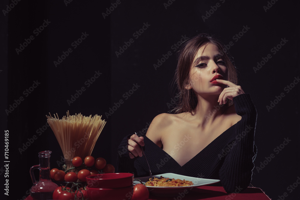 Obraz premium Eating Spaghetti pasta. Portrait of young Woman Eating Spaghetti pasta. Eating pasta. Woman eat spaghetti with sauce. Good pasta. Girl eats spaghetti. Healthy eating. Sexy kitchen. Finger lick mouth.