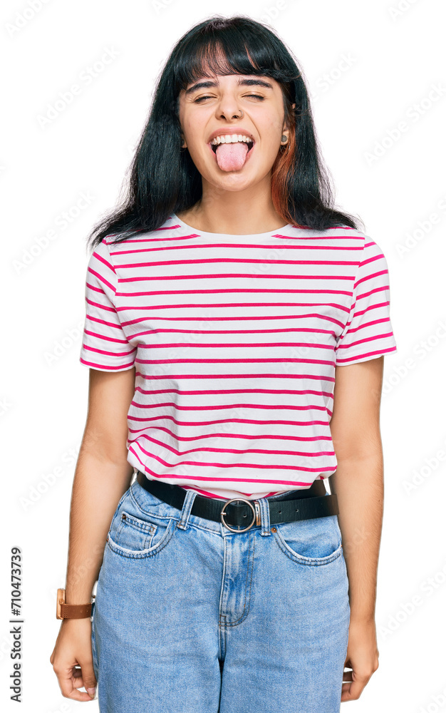 Obraz premium Young hispanic girl wearing casual clothes sticking tongue out happy with funny expression. emotion concept.
