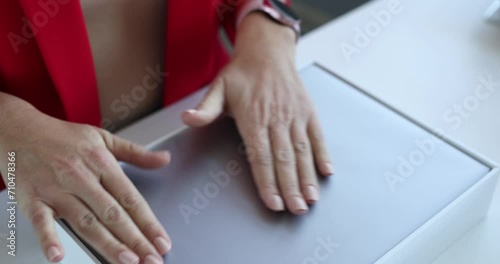 Minsk, Belarus, November 23, 2021: Woman woman takes new one out of box of Apple Macbook Air. Applications for App Store in iTunes photo
