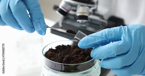 Scientist in laboratory conducts soil research in test tube. Mineralogical soil analysis concept photo