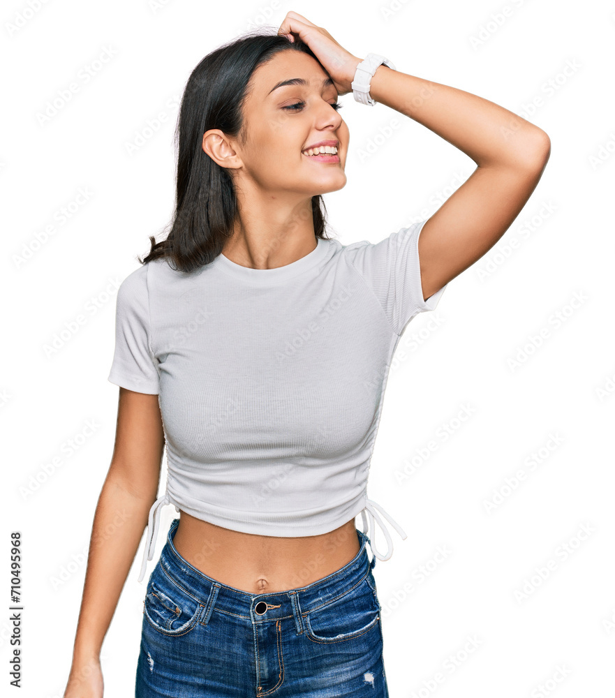 Obraz premium Young hispanic girl wearing casual white t shirt smiling confident touching hair with hand up gesture, posing attractive and fashionable
