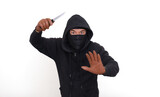 Bad guy in his black hoodie, raising his hand with a knife to threat the victim