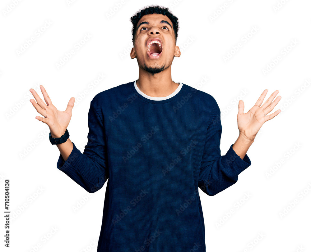 Naklejka premium Young african american man wearing casual clothes crazy and mad shouting and yelling with aggressive expression and arms raised. frustration concept.
