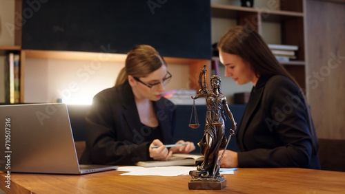 A female lawyer at her workplace communicates with a young client, discussing issues of legal significance. Consultation concept with legal and financial issues