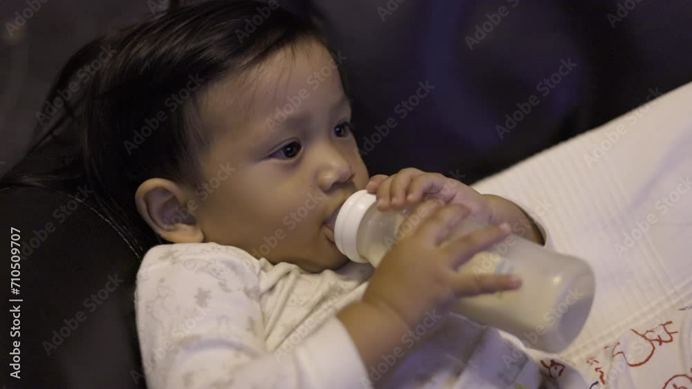 Little boy with a bottle in his hands and a pacifier in his mouth. Little boy with a bottle in his hands and a pacifier in his mouth.