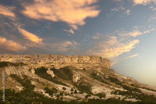 Mountain canyon in the dry season against the backdrop of sunset and pink clouds. White Rock, Crimea.