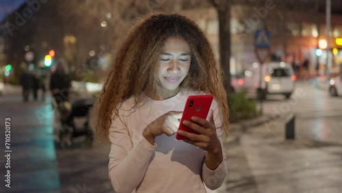 Latin Woman Communicating on Smartphone Amidst City Lights at Night