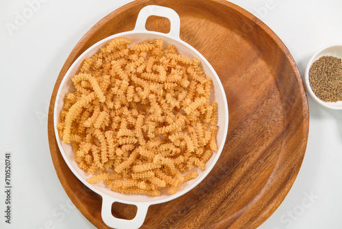 Butter murukku – also known as benne murukku, benne chakli or venna murukku. Murukku is a deep fried crisp snack made with rice flour and gram flour. Crispy and Deep Fried muruku.  photo