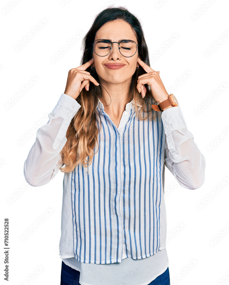 Beautiful hispanic woman wearing casual striped shirt covering ears with fingers with annoyed expression for the noise of loud music. deaf concept. Beautiful hispanic woman wearing casual striped shirt covering ears with fingers with annoyed expression for the noise of loud music. deaf concept.