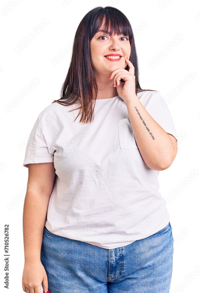 Young plus size woman wearing casual clothes looking confident at the camera smiling with crossed arms and hand raised on chin. thinking positive. Young plus size woman wearing casual clothes looking confident at the camera smiling with crossed arms and hand raised on chin. thinking positive.
