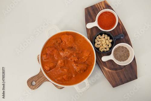 Tasty butter chicken curry dish from Indian cuisine. Tasty butter chicken curry, Murg Makhanwala or masala. Butter chicken tikka masala served with roti / Paratha and plain rice along with onion salad
