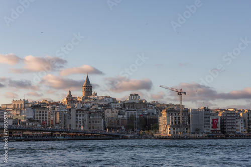 Istanbul, Turkey - 23 April 2023: View of the Galata Tower in Beyoglu district at sunset along the Golden Horn Strait, Istanbul downtown, Turkey. photo