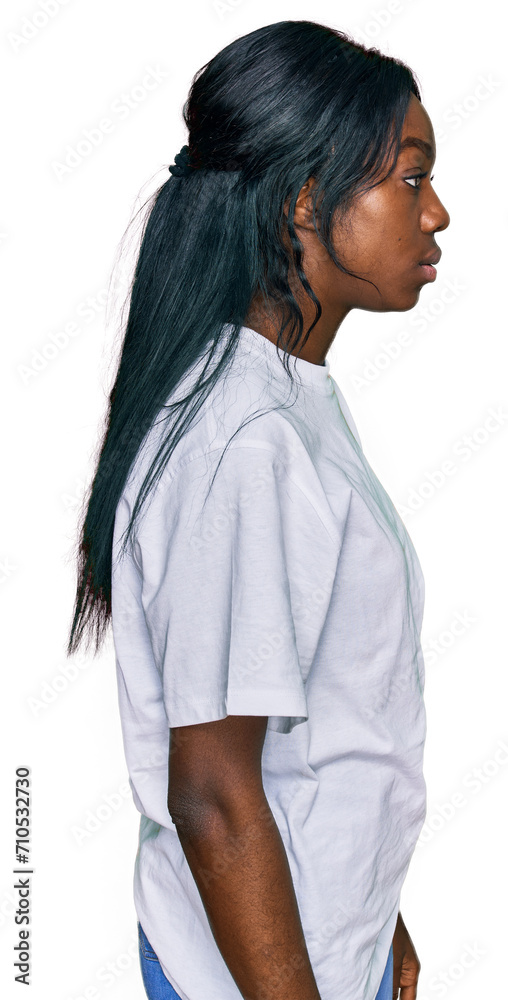 Young african american woman wearing casual white t shirt looking to side, relax profile pose with natural face with confident smile. Young african american woman wearing casual white t shirt looking to side, relax profile pose with natural face with confident smile.