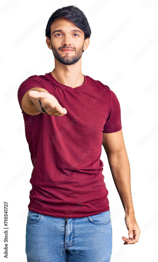 Handsome hispanic man wearing casual clothes smiling cheerful offering palm hand giving assistance and acceptance. Handsome hispanic man wearing casual clothes smiling cheerful offering palm hand giving assistance and acceptance.