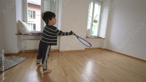 Starting Fresh scene of Young Boy's Tennis Practice in Vacant Apartment bedroom. New home, family moving to new apartment concept photo