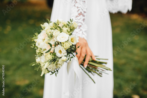 Wedding bouquet close-up photo. The bride in a white dress holds beautiful flowers in her hands