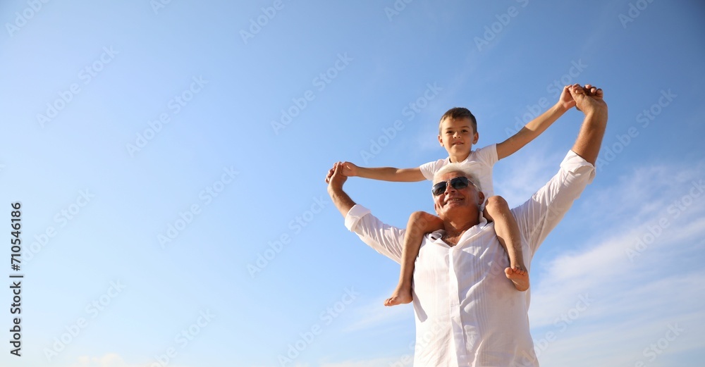 Cute little boy with grandfather spending time together near sea Cute little boy with grandfather spending time together near sea