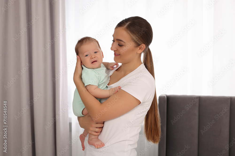 Mother holding her cute newborn baby at home