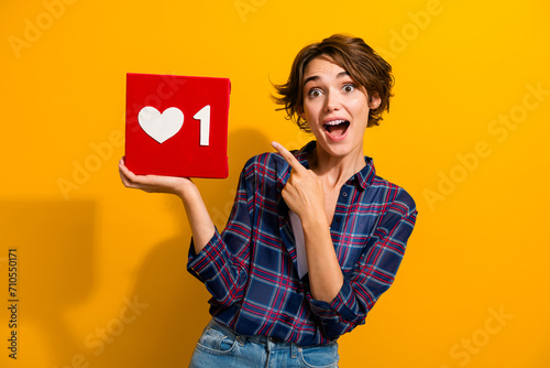 Portrait of excited impressed girl with bob hairstyle wear plaid blouse directing at like reaction isolated on yellow color background