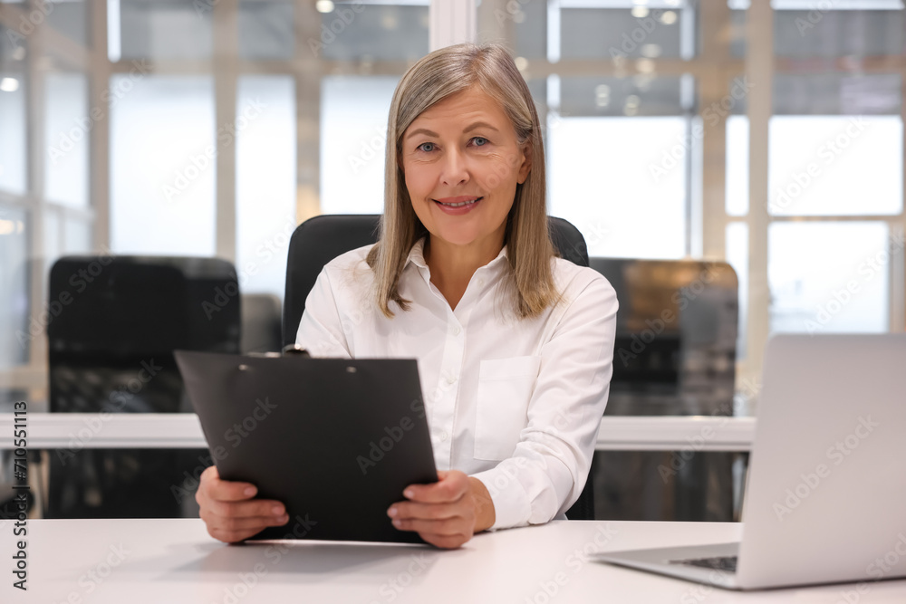Smiling woman with clipboard working in office. Lawyer, businesswoman, accountant or manager Smiling woman with clipboard working in office. Lawyer, businesswoman, accountant or manager