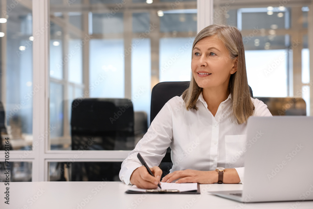 Smiling woman with clipboard and laptop working in office, space for text. Lawyer, businesswoman, accountant or manager Smiling woman with clipboard and laptop working in office, space for text. Lawyer, businesswoman, accountant or manager