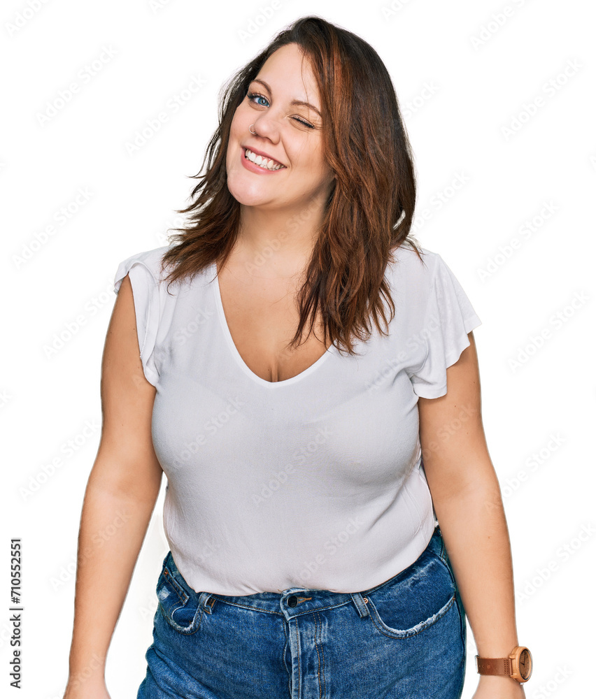 Young plus size woman wearing casual white t shirt winking looking at the camera with sexy expression, cheerful and happy face. Young plus size woman wearing casual white t shirt winking looking at the camera with sexy expression, cheerful and happy face.