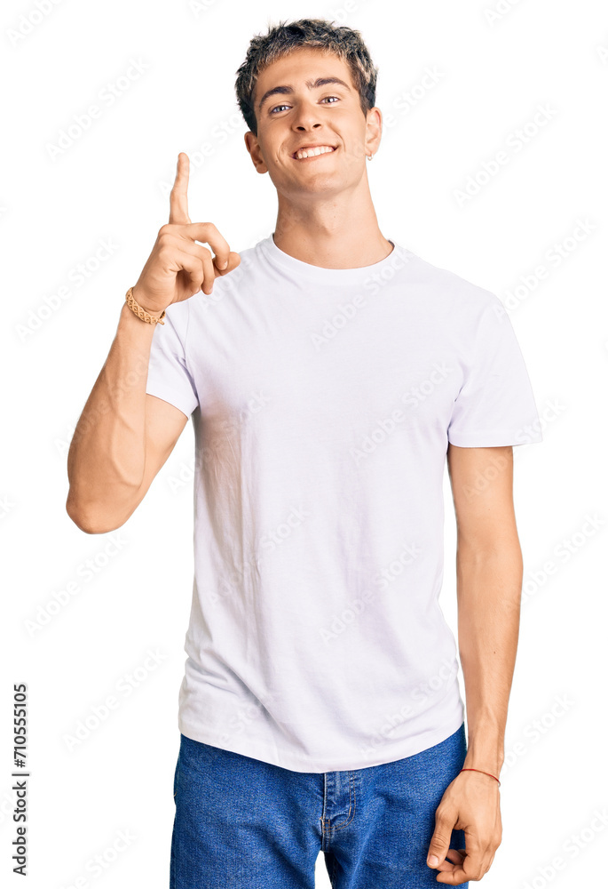 Young handsome man wearing casual white tshirt showing and pointing up with finger number one while smiling confident and happy. Young handsome man wearing casual white tshirt showing and pointing up with finger number one while smiling confident and happy.
