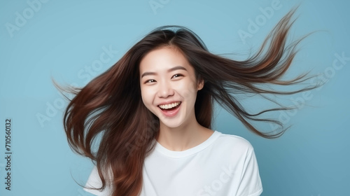 Happy Asian woman on blue background.