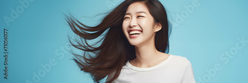 Happy Asian woman on blue background. photo