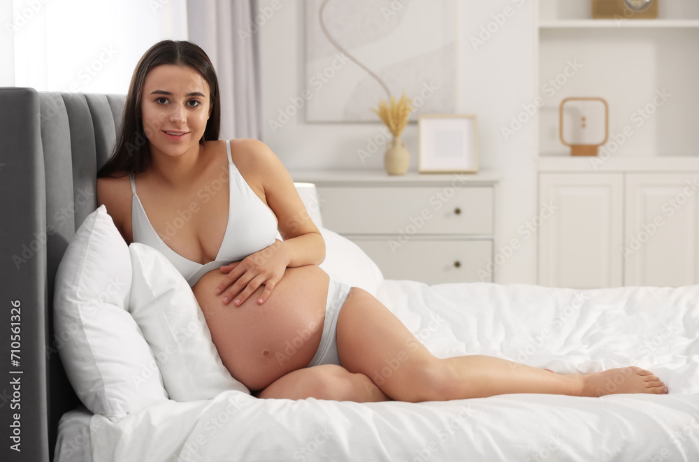 Beautiful pregnant woman in stylish comfortable underwear on bed at home Beautiful pregnant woman in stylish comfortable underwear on bed at home