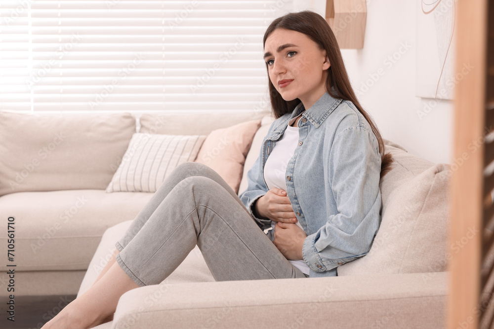 Young woman suffering from stomach pain at home Young woman suffering from stomach pain at home