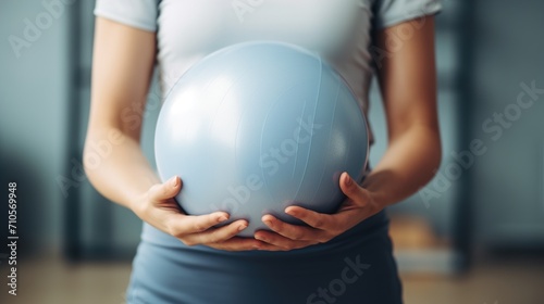 Young physiotherapist woman holding pilates ball photo