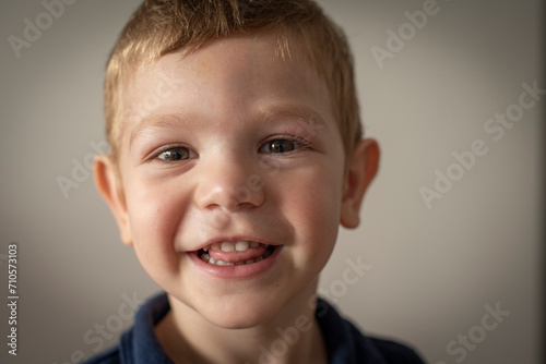 Retrato de niño pequeño rubio sonriendo mirando a la cámara 