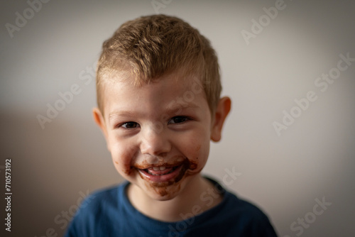 Retrato de niño rubio sonriendo con la boca sucia de chocolate photo