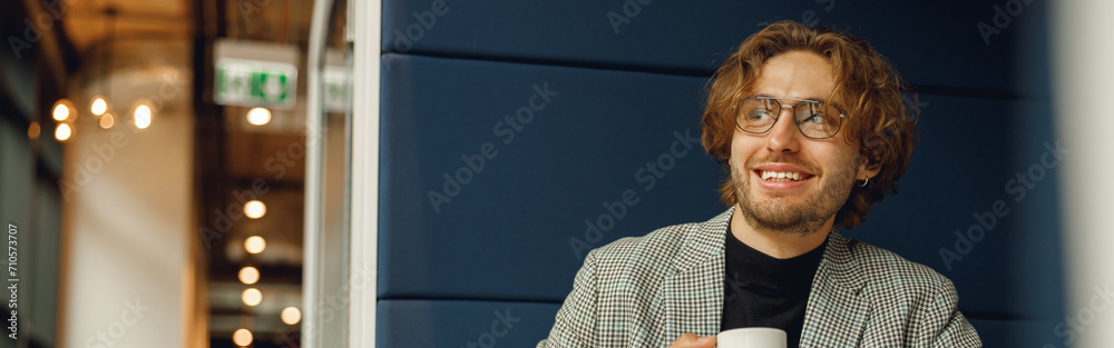 Smiling businessman sitting with coffee in office during break time. High quality photo Smiling businessman sitting with coffee in office during break time. High quality photo