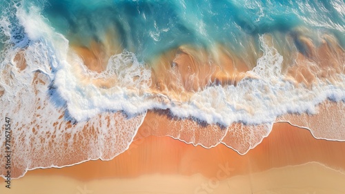 Aerial view of colourful sand and crystal clear blue ocean.