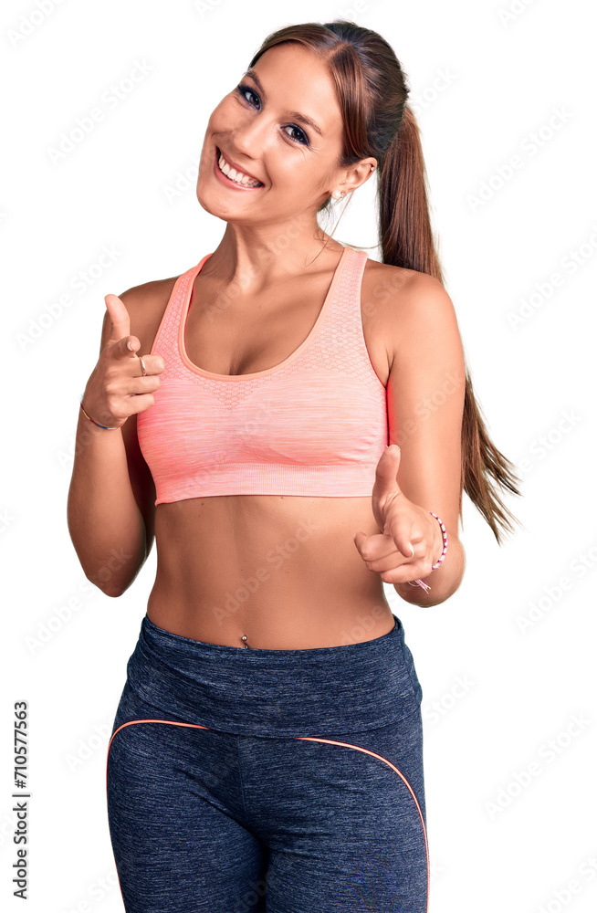 Young beautiful hispanic woman wearing sportswear pointing fingers to camera with happy and funny face. good energy and vibes. Young beautiful hispanic woman wearing sportswear pointing fingers to camera with happy and funny face. good energy and vibes.