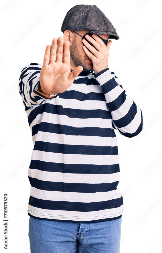 Young handsome man wearing burglar mask covering eyes with hands and doing stop gesture with sad and fear expression. embarrassed and negative concept. Young handsome man wearing burglar mask covering eyes with hands and doing stop gesture with sad and fear expression. embarrassed and negative concept.