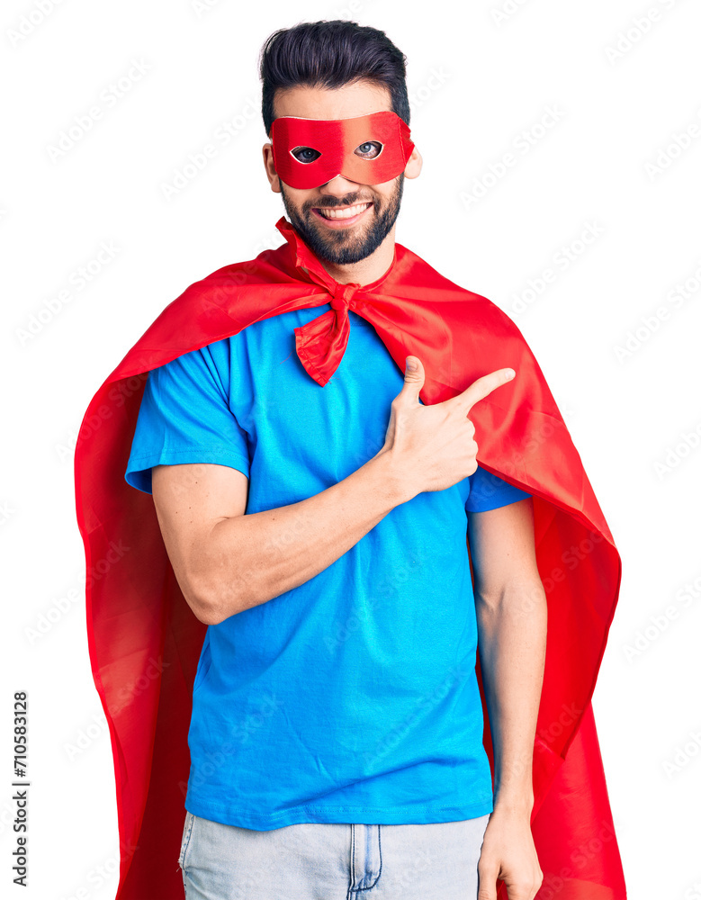 Young handsome man with beard wearing super hero costume cheerful with a smile of face pointing with hand and finger up to the side with happy and natural expression on face Young handsome man with beard wearing super hero costume cheerful with a smile of face pointing with hand and finger up to the side with happy and natural expression on face