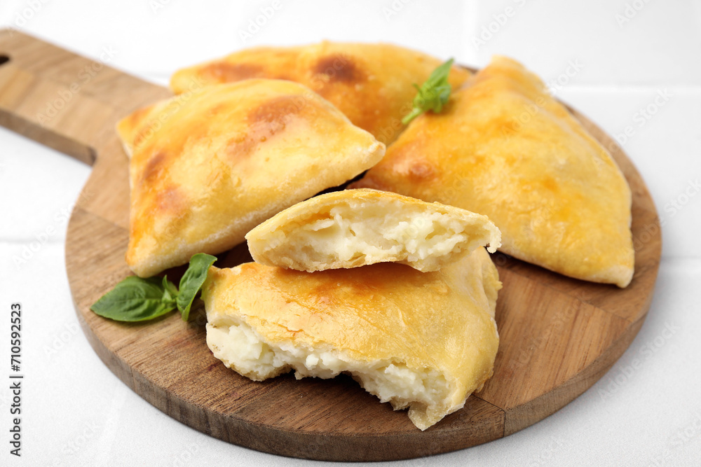 Delicious samosas and basil on white tiled table, closeup Delicious samosas and basil on white tiled table, closeup