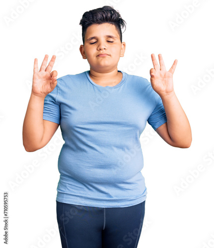 Little boy kid wearing sports workout clothes relax and smiling with eyes closed doing meditation gesture with fingers. yoga concept.