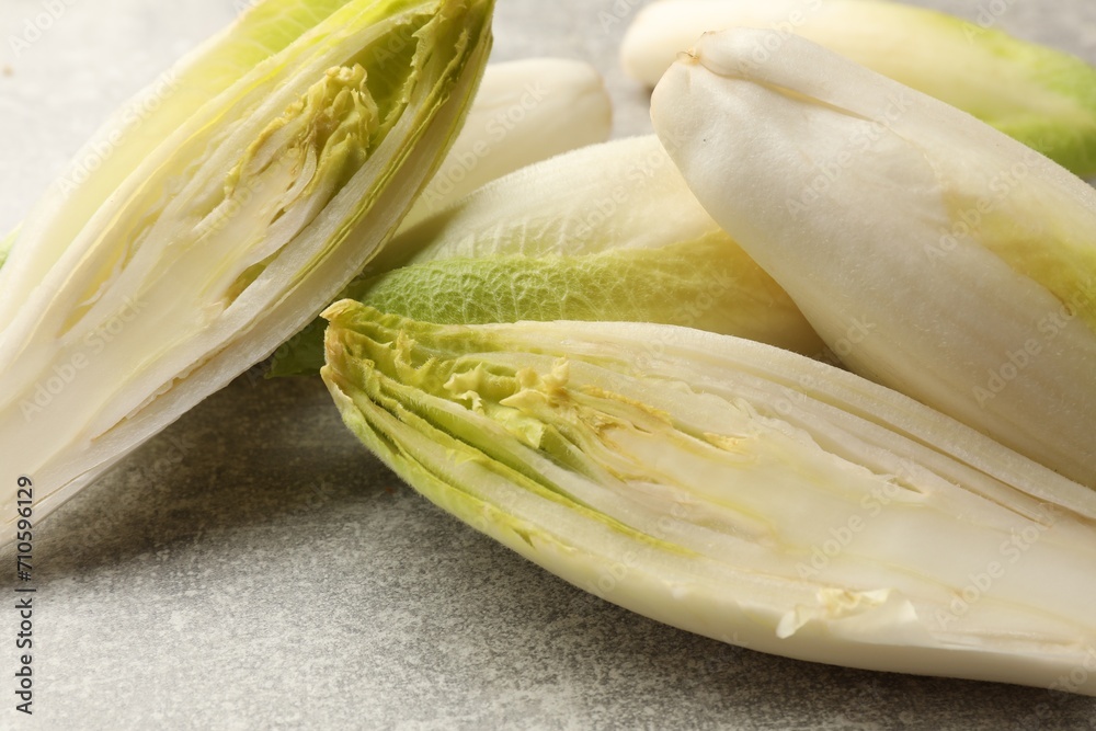 Fresh raw Belgian endives (chicory) on light grey table, closeup Fresh raw Belgian endives (chicory) on light grey table, closeup