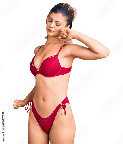 Young beautiful woman wearing bikini stretching back, tired and relaxed, sleepy and yawning for early morning © Krakenimages.com