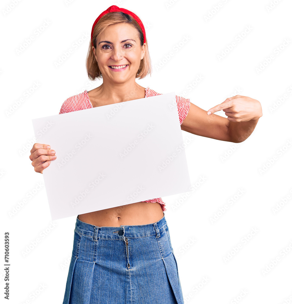 Young blonde woman holding blank empty banner smiling happy pointing with hand and finger Young blonde woman holding blank empty banner smiling happy pointing with hand and finger