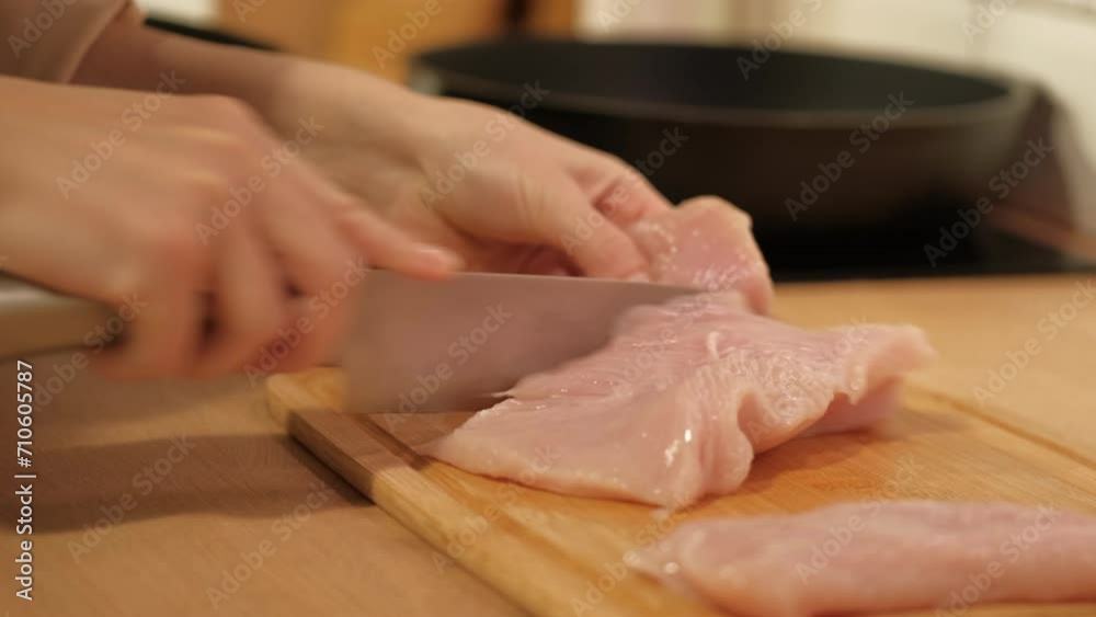 A woman's hand cuts white meat. Cooking at home. Healthly food A woman's hand cuts white meat. Cooking at home. Healthly food