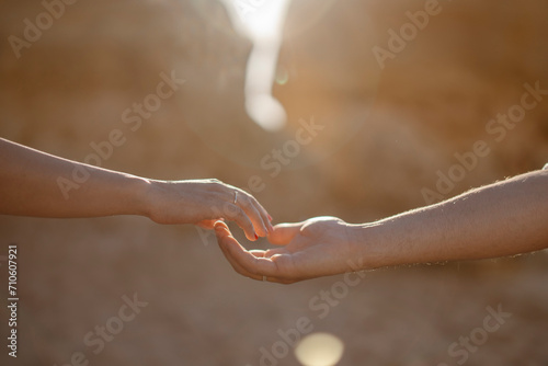 Man and woman stretching hands to each other at the beach