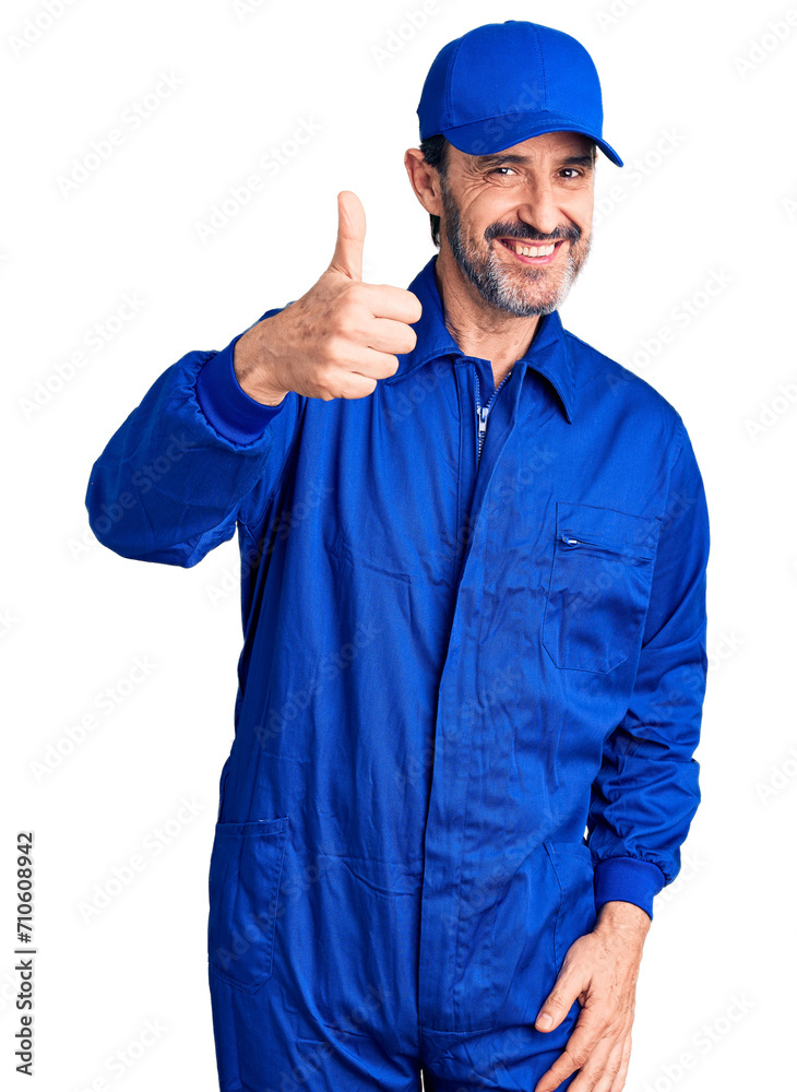 Middle age handsome man wearing mechanic uniform doing happy thumbs up gesture with hand. approving expression looking at the camera showing success.