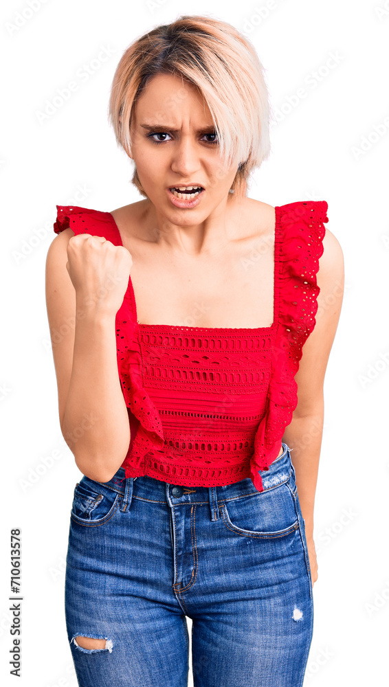 Young beautiful blonde woman wearing casual clothes angry and mad raising fist frustrated and furious while shouting with anger. rage and aggressive concept. Young beautiful blonde woman wearing casual clothes angry and mad raising fist frustrated and furious while shouting with anger. rage and aggressive concept.