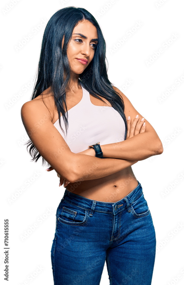 Beautiful hispanic woman wearing casual clothes looking to the side with arms crossed convinced and confident Beautiful hispanic woman wearing casual clothes looking to the side with arms crossed convinced and confident