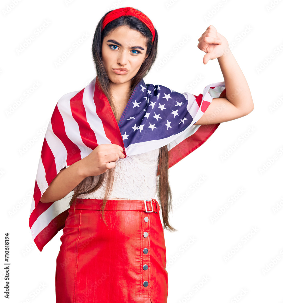 Brunette teenager girl holding united states flag with angry face, negative sign showing dislike with thumbs down, rejection concept Brunette teenager girl holding united states flag with angry face, negative sign showing dislike with thumbs down, rejection concept